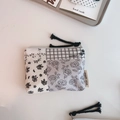 Detail of floral and checkered fabric coin pouch with black woven zipper handle strap - Black Grey Grid Stripe Floral Patchwork