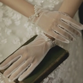 Detail showing white sheer mesh gloves with pearl bead wrist decoration on book - White Mesh Pearl Beaded (ST097)