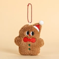 Gingerbread man plush keychain with red Christmas hat and green buttons on a brown surface - Gingerbread Man