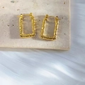 Macro shot of gold rectangular hoop earrings with hammered texture on a stone surface - Rectangular Hammered Texture Style (EH346)