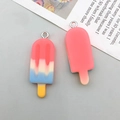Macro detail of colorful resin ice cream pendants with gradient finish and metal loops - Rose Red