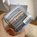 Close-up of spiral hair ties set in a transparent square box with a branded ribbon - Coffee Black Series Set