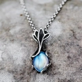 Macro view of vintage silver leaf pendant with blue moonstone on a stone background - Fish Tail Pendant