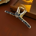Detalle de la pinza para el pelo retro dorada con esmalte de corazón y adornos de perlas - Pinza de pelo de flor de corazón de oro negro
