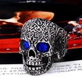 Macro shot of gothic silver skull ring with blue gemstone eyes and intricate carvings - Adjustable Open / Vintage Silver - Blue Eyes