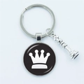 Silver chess king pendant keychain with crown motif on a black circular base - Crown