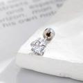 Stervormige zirkonia oorknop met zilveren metalen zetting op een witte stenen ondergrond - Witte Ster (Enkel)