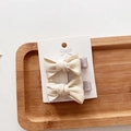 Detailed view of two cream white fabric bow hair clips on a wooden tray background - 2-Piece Set / Off White