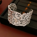 Macro di un ampio bracciale rigido aperto in argento stile lava liquida con finitura lucida - Bracciale - Argento / Argento