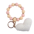 Detailed shot of pink silicone beads bracelet with white crochet heart and gold keychain - White