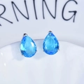 Gros plan de boucles d'oreilles gouttes bleues serties d'argent sur un plateau en céramique - Boucles d'Oreilles Clous Pierre Bleue (Paire)