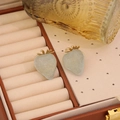 Cute light green strawberry stud earrings with gold leaves on a brown leather jewelry box - Blue