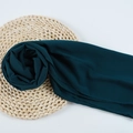 Dark green chiffon hijab scarf with textured fabric displayed on a woven mat - 118