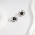 Close-up of silver fan-shaped earrings featuring a round black cat eye stone inlay - Black