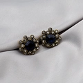 Macro detail of vintage gold flower stud earrings with deep blue gemstones and white crystals - Deep Blue Gem Vintage Flower Studs