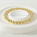 Detail view of 18K gold plated elastic bead bracelet with 6mm polished beads - 6mm / Gold