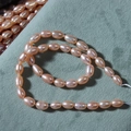 Strand of high luster 5-6mm pink-orange freshwater oval rice pearls for jewelry making - Pink