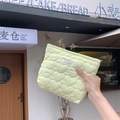 Detailaufnahme der herzgesteppten Kosmetiktasche in Limonengrün mit Webetikett - Gelb
