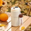 Detail of white insulated coffee mug with beige strap and leather tag on a wooden table - Smart Model / White