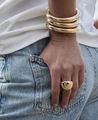 Close-up of stacked gold-finish wide dome bangles and chunky ring on a model - Gold Smooth Plain Circle Bangle
