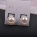 Classic white freshwater round pearl stud earrings with mirror luster on a display card - 9mm / White