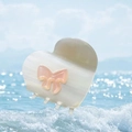 Cream white acetate heart hair claw clip with pink bow detail against a beach background - Striped Colorful White Heart Bow Claw (Approx. 7cm)