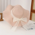 Light pink woven straw sun hat for women featuring elegant white lace bow and wavy edge - Lace Water Grass Pink