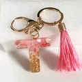 Letter T resin keychain featuring pink gravel gold foil and a matching pink tassel - Letter T