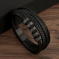 Detalle de una pulsera multicapa de cuero negro trenzado con anillos metálicos en madera - Negro + Negro Mate