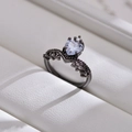 Makro-Detail eines gotischen schwarzen Rings mit herzförmigem Edelstein auf Leder - Weiß