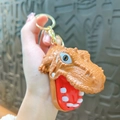 Brown dinosaur head keychain with open mouth and white teeth in a detailed handheld view - Coffee Dinosaur