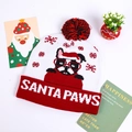 Close-up of knit Christmas hat with French Bulldog pattern and Santa Paws text detail - Red White Dog With Glasses