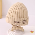 Gros plan du bonnet tricoté beige pour bébé avec broderie Lucky et motif ours - 2-5 Ans / Beige