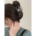 Silver spider hair claw clip with crystal and pearl pendant on a model's hairstyle - Spider Pearl Hair Claw / White Gold