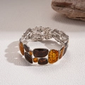 Nahaufnahme von Bernstein-Leoparden-Resin-Einsätzen auf gehämmertem silbernem Armband - Silberne Basis Kaffee (Armband-Kaffee)