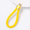 Detalle de llavero de cuero trenzado amarillo con cierre dorado y adorno de corazón - Cuerda Amarilla (Labio Amarillo)