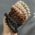 Elastic wavy hair ties in neutral black, brown, and beige tones shown on a hand - Spiral Mixed 10pcs (Loose)