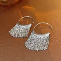 Close-up of silver tassel hoop earrings with sparkling rhinestones on textured surface - C-Shape Hoop Tassel (3#)