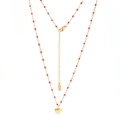 Vue détaillée du collier en acier inoxydable doré avec perles rouges et pendentif cœur - Perles Rouges