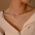 Primo piano di una collana dorata a due strati con stella a otto punte e ciondolo in zircone - Stile Zircone a Stella Stratificato (0416)