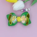 Detalle de un lazo de cinta con un corazón transparente lleno de lentejuelas de estrellas - Amarillo y Verde