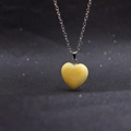 Minimalist necklace featuring a yellow heart-shaped gemstone pendant on black background - Heart Topaz