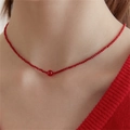 Delicate red beaded choker necklace with a central larger bead on a model - Red Agate Necklace