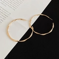 Detailed view of gold twisted metal hoop earrings with elegant wavy texture on paper - Silver Earring Post Style / 5cm / Gold