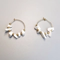 Detail view of gold hoop earrings featuring irregular white stone beads and gold accents - White Turquoise