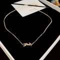 Detailed view of a gold metal YSL logo pendant chain in a black jewelry box - Necklace - Gold