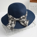 Navy blue straw sun hat with decorative black and white checkered bow and wide brim - Navy Blue
