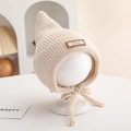 Close-up of beige knit baby pointed hat with soft ribbed texture and chin straps - 6-18 Months / Beige