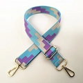 Close-up of geometric pattern crossbody bag strap with polished gold-tone metal hooks - Light Blue