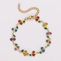 Detail of bohemian gold cherry bracelet with colorful gemstone fruit and green enamel leaves - Colorful